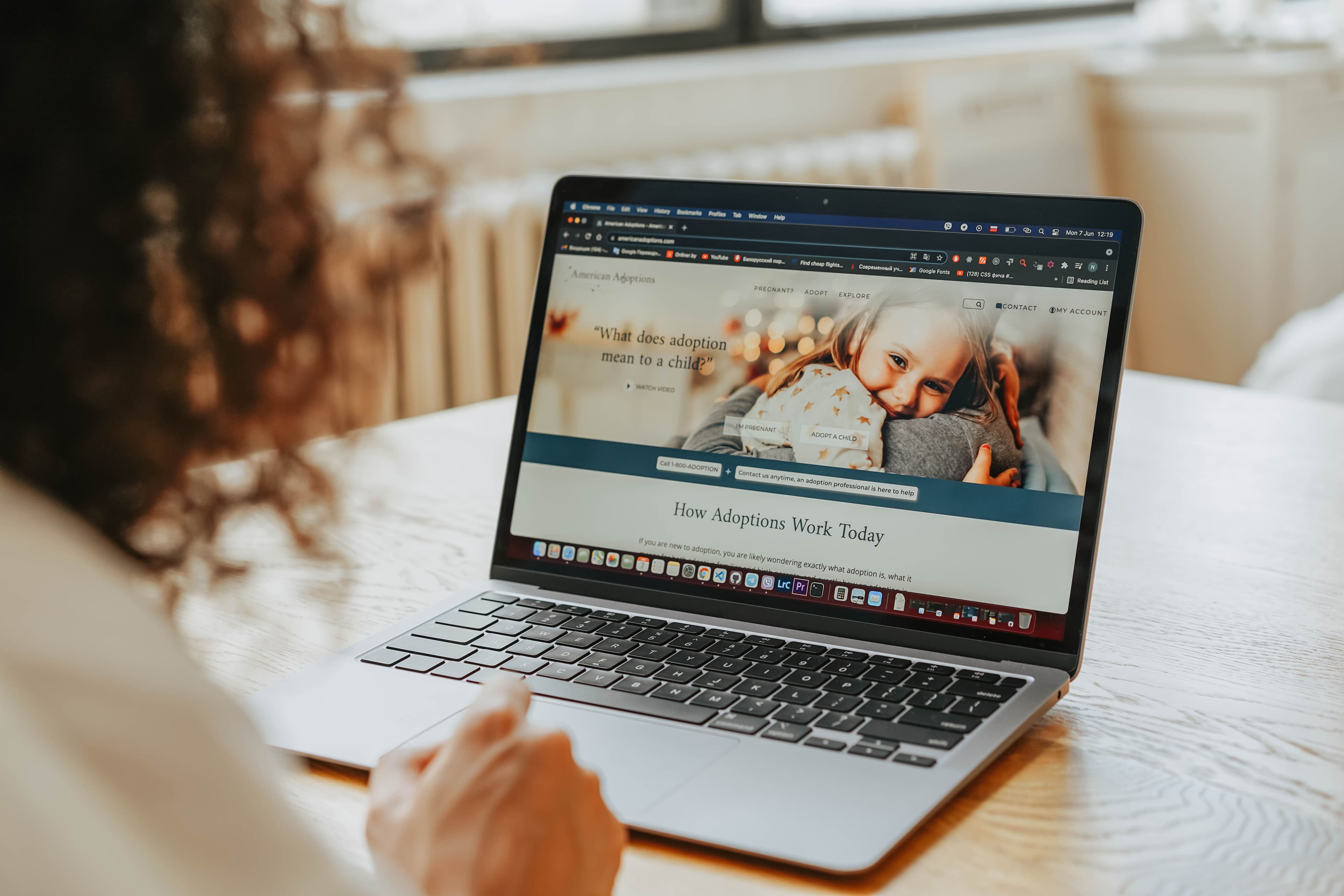 Woman viewing an adoption nonprofit website on a laptop, highlighting a user-focused nonprofit website experience